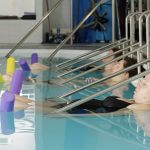 Trois femme alignées en train de se détendre pendant un cours d'aquagym prénatale