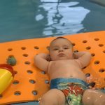 Un bébé qui flotte sur une plateforme dans une piscine