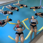 Un groupe de femme pendant un cours d'aquagym prénatal