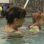 Une maman et son bébé dans l'eau pendant une séance